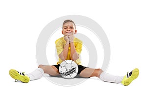 A cute young sportsman in a yellow T-shirt and black shorts sitting on a floor isolated on a white background.