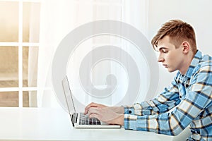 Cute young student using laptop