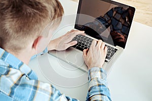 Cute young student using laptop