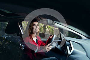 Cute young success happy brunette woman driving a car and smiling
