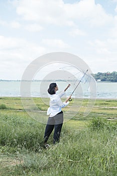 Cute young thai woman flying with transparency umbrella