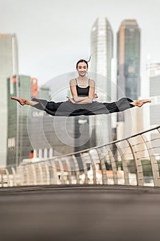 Cute Young woman athlete performs a perfect straddle leap high u photo