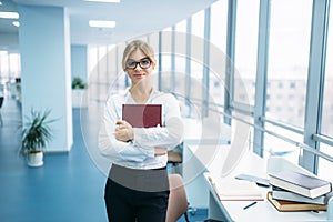 Cute young woman with book in library