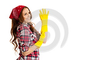 Cute young woman in checkered shirt with yellow rubber gloves re