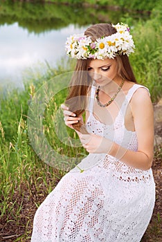 Cute young woman with circlet of camomile