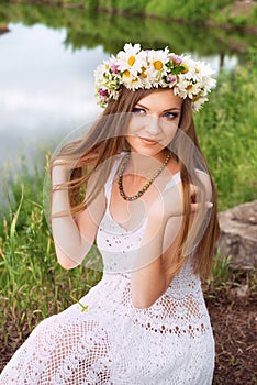 Cute young woman with circlet of camomile