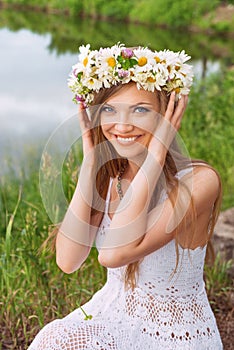 Cute young woman with circlet of camomile