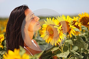 Cute young woman enjoying sunflowers