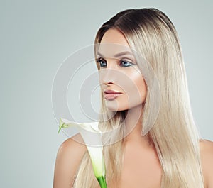 Cute Young Woman with Fresh Skin, Healthy Hair and Lily Flowers