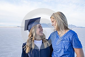 Cute Young woman in her graduation cap and gown celebrating with her mom photo