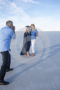 Cute Young woman in her graduation cap and gown taking a picture with her mom