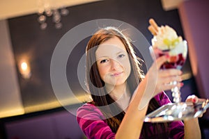 Cute young woman in an ice cream parlor