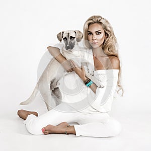 Cute young woman kisses and hugs her puppy mongrel dog. Love between owner and dog. Isolated on white background. Studio portrait