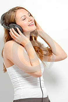 Cute young woman listens to headphones