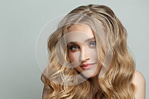 Cute young woman with long healthy curly hair close up portrait