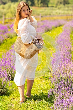 Cute young woman looking back as she walks through lavender