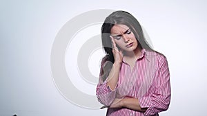 A cute young woman makes a sad face on a white background