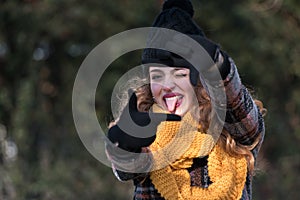 Cute young woman at the park stick tongue out