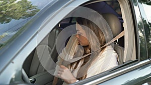 Cute young woman parked car, unfasten seat belt and got out of car. Auto test-drive, leasing, buying, renting concept