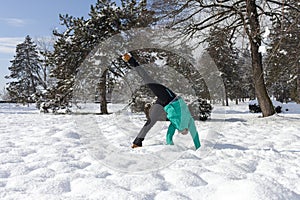 Cute young woman performing cartwheel