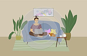 Cute young woman sitting on the couch with laptop computer in cozy room with your cat.