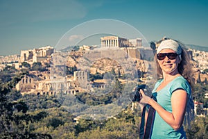 Cute young woman takes a picture of the Acropolis, Athens