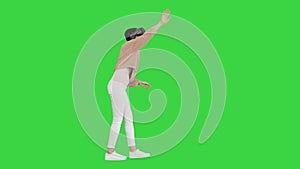 Cute young woman walking and using interactive VR headset on a Green Screen, Chroma Key.