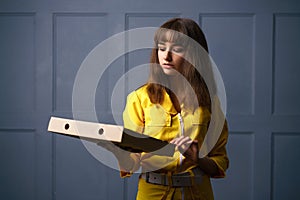 Cute young woman in a yellow jumpsuit delivering pizza.