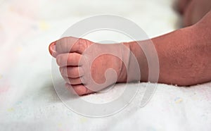 Cutes foot of newborn baby in postpartum care unit in hospital when she sleeping with her mother . photo