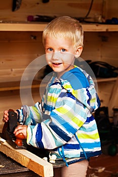 Cutest boy in the workshop of a carpenter planed