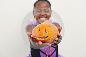 Cutest pumpkin in the patch. Shot of a little girl holding a jack o lantern against a white background.