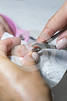 Cuticle Cutting. Woman hands receiving manicure and nail care procedure. Close up concept. Manicurist pushing cuticles on female`