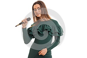 Cutie brunette woman in elegnat green dress with microphone