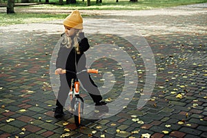 Cutie little girl rides on bicycle at the park