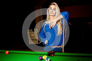 Cutie young blonde with blue eyes plays pool billiard