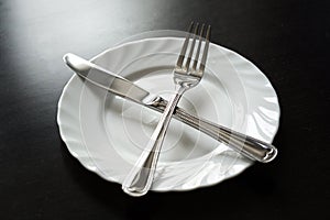 Cutlery on a black background. Fork, spoon, knife, plate