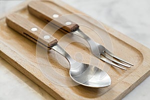 Cutlery for dessert on wooden plate