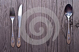 Cutlery kitchenware on old wooden boards background