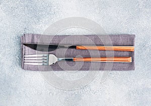 Cutlery knife and fork on a napkin  gray concrete background  copy space top view