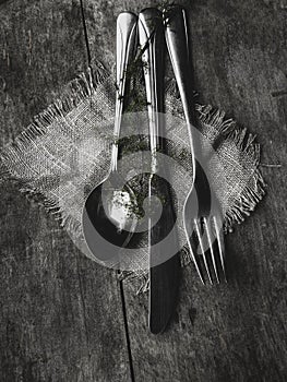 cutlery Knife, fork, spoon green branch on a old wooden table, toned Top view, flat lay, copy space