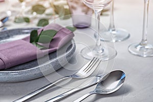 Cutlery, plate and napkin on light background, closeup