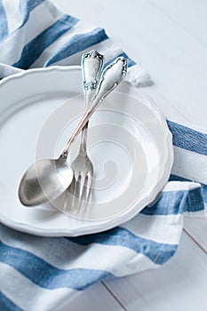 Cutlery, porcelain plate and white linen napkin