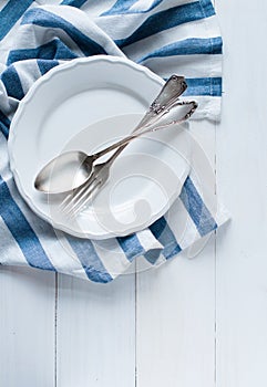 Cutlery, porcelain plate and white linen napkin