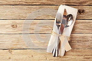 Cutlery Tied on Napkin with Tag on Wooden Table photo