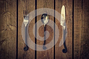 Cutlery - Vintage Fork, Spoon and Knife on Wood Background