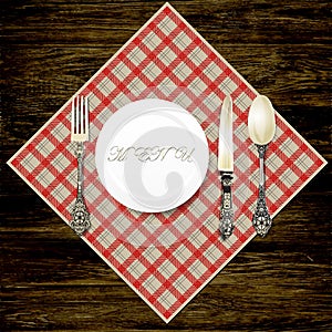 Cutlery on a wooden table and a checkered napkin