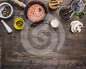 Cutlet of ground beef in a small frying pan, sliced mushrooms, pepper, herbs and salt border ,place text wooden rustic back