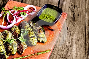 cutlet roll with green sauce Fried cutlets in bread crumbs, isolated kept on table along with onion slice