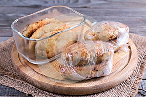 Cutlets in a container on a wooden table