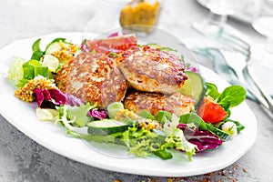 Cutlets and fresh vegetable salad on white plate. Fried meatballs with vegetable salad